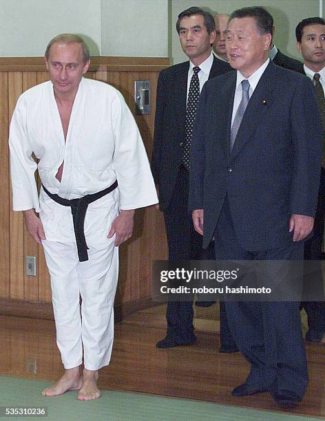 Russian President Vladimir Putin bows before entering Kodokan Judo Hall in Tokyo. He is escorted by Japanese Prime Minister Yoshiro Mori.