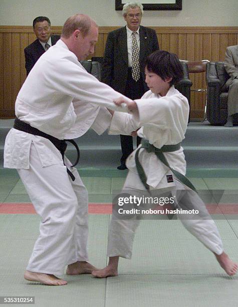 Russian president Vladimir Putin in Judo gear struggles against 10-year-old Japanese schoolgirl Natsumi Gomi on a tatami mat as he visits Kodokan...