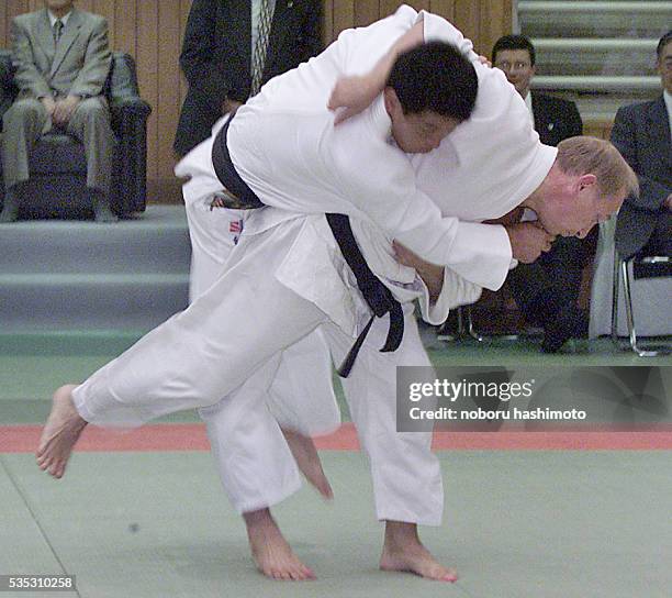 Russian President Vladimir Putin throws a Japanese judo expert during a judo exercise at the Kodokan Judo Hall in Tokyo. Putin has a black belt in...
