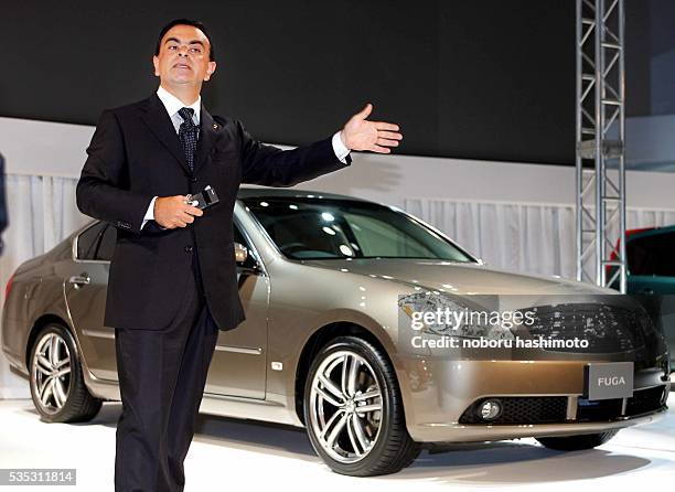Nissan President Carlos Ghosn shows off the new sedan Fuga at a Yokohama exhibition.