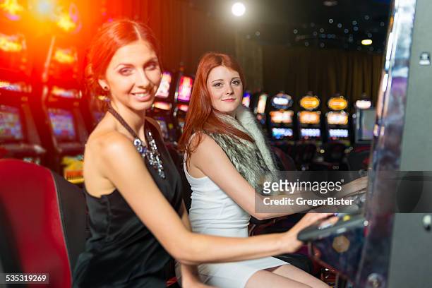 friends gambling in the casino on slot machines - teen pokies stock pictures, royalty-free photos & images