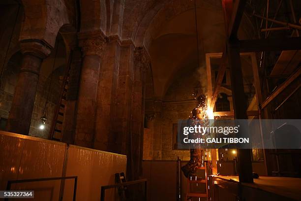 Worker welds scaffoldings at the Church of the Holy Sepulchre in Jerusalem's Old City on May 29 ahead of restoration of the Tomb of Jesus. The tomb...