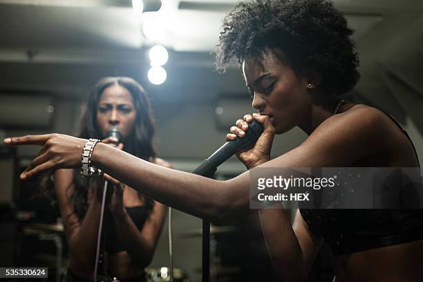 young women singing in a recording studio - gesangskunst stock-fotos und bilder