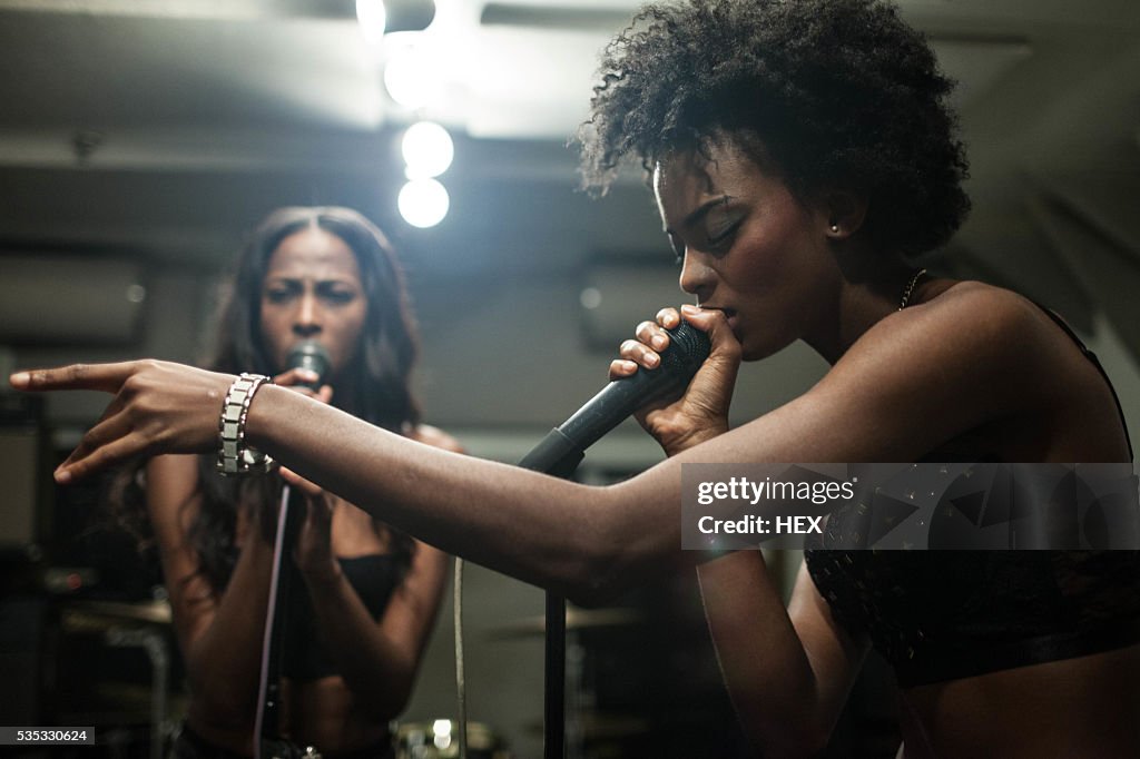 Young women singing in a recording studio
