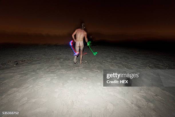 young man streaking on a beach at night - man skinny dipping stock pictures, royalty-free photos & images