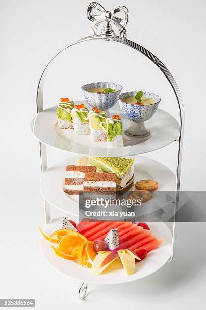 tiered stand with sushi,pudding,cakes,biscuit and assorted fresh fruits - cakestand stock-fotos und bilder