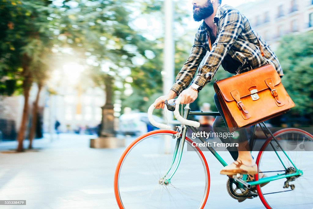 Young hipster man speeding with his bike.