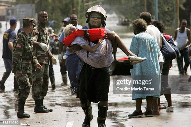 Woman is carried out of flood waters after being trapped in her home in Orleans parish during the aftermath of Hurricane Katrina August 30, 2005 in...