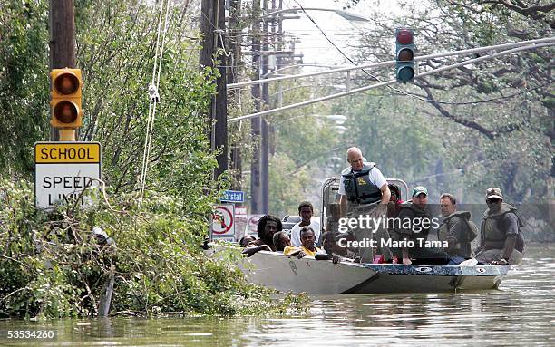 People are taken ashore in a boat after being rescued from their homes in high water in Orleans parish after Hurricane Katrina August 30, 2005 in New...