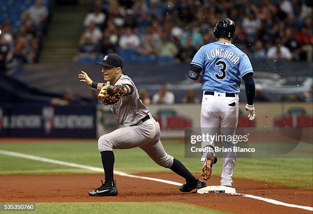 Evan Longoria of the Tampa Bay Rays beats first baseman Dustin Ackley of the New York Yankees to first base on his fielder's choice during the first...