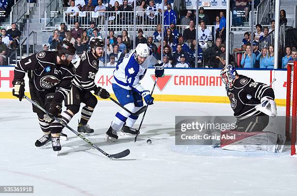 Erik Burgdoerfer and Ryan Stanton of the Hershey Bears watch Josh Leivo of the Toronto Marlies take a shot on Justin Peters of the Bears during AHL...