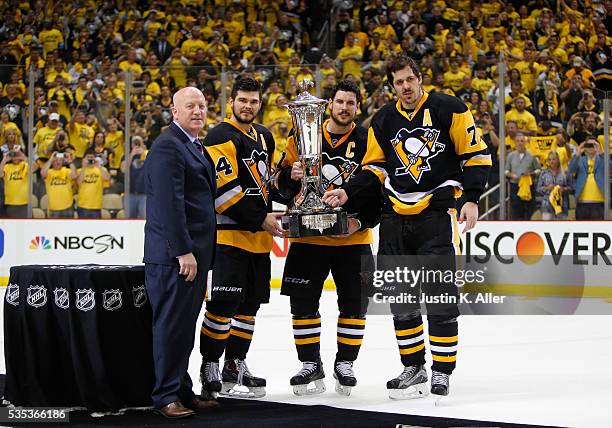 Deputy Commissioner Bill Daly presents Chris Kunitz, Sidney Crosby and Evgeni Malkin of the Pittsburgh Penguins with the Prince of Wales Trophy after...