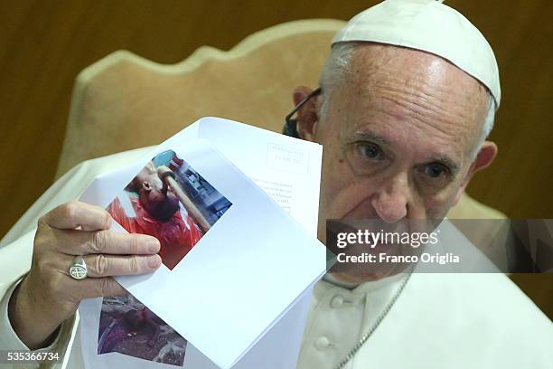 Pope Francis shows a picture of a child with an axe in his head during 'Un Muro o Un Ponte' Seminary held by Pope Francis at the Paul VI Hall on May...