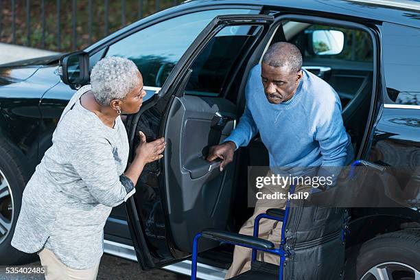 senior woman helping disabled husband out of car - disembarking stock pictures, royalty-free photos & images