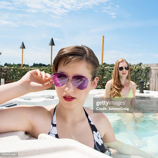 niña usando gafas de sol mientras se relaja en la bañera de hidromasaje climatizada - girls in hot tub fotografías e imágenes de stock