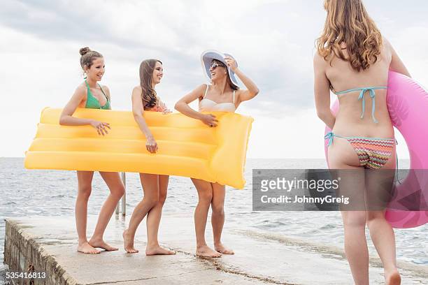 cheerful friends with inflatable raft and ring - young teen bathing suit stock pictures, royalty-free photos & images