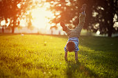 Little boy standing on hands on grass