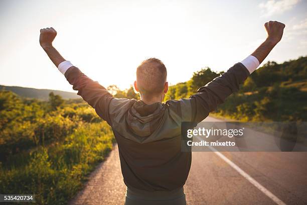 hombre plantear brazos - arms outstretched fotografías e imágenes de stock