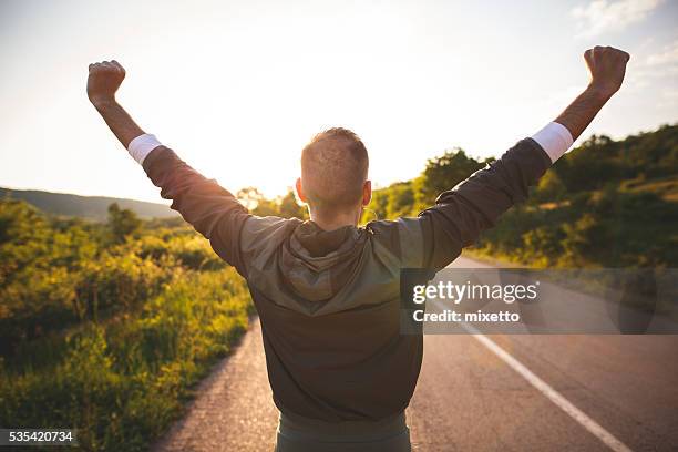 homem levantar braços - motivação imagens e fotografias de stock