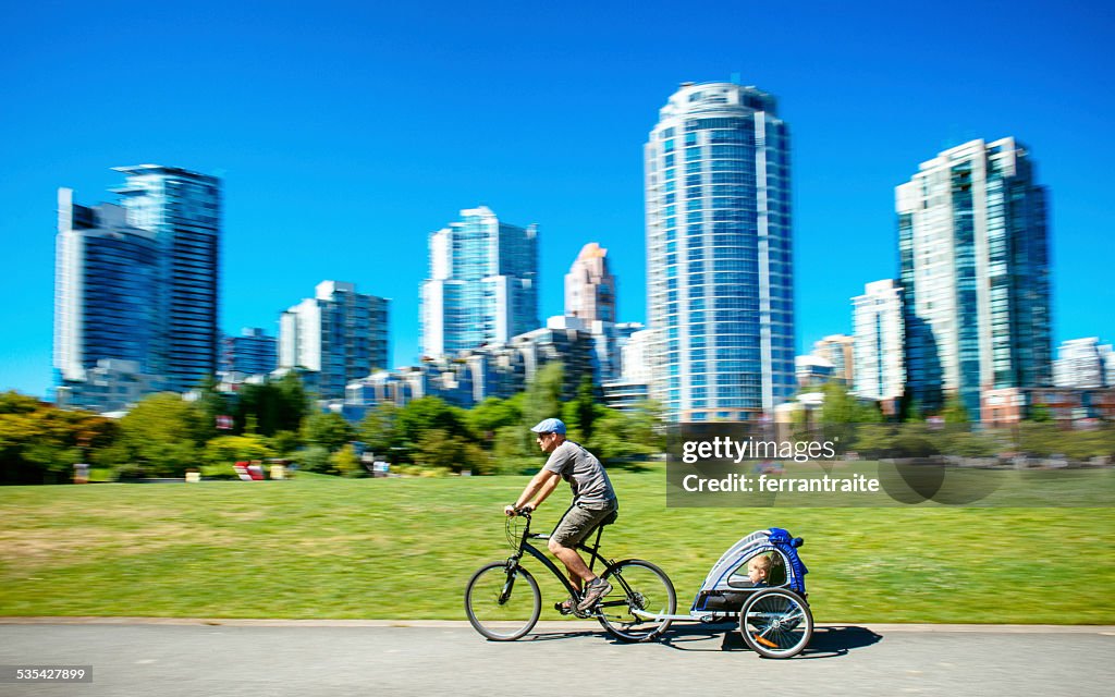 Pai tem filho na bicicleta reboque em Vancouver no Canadá