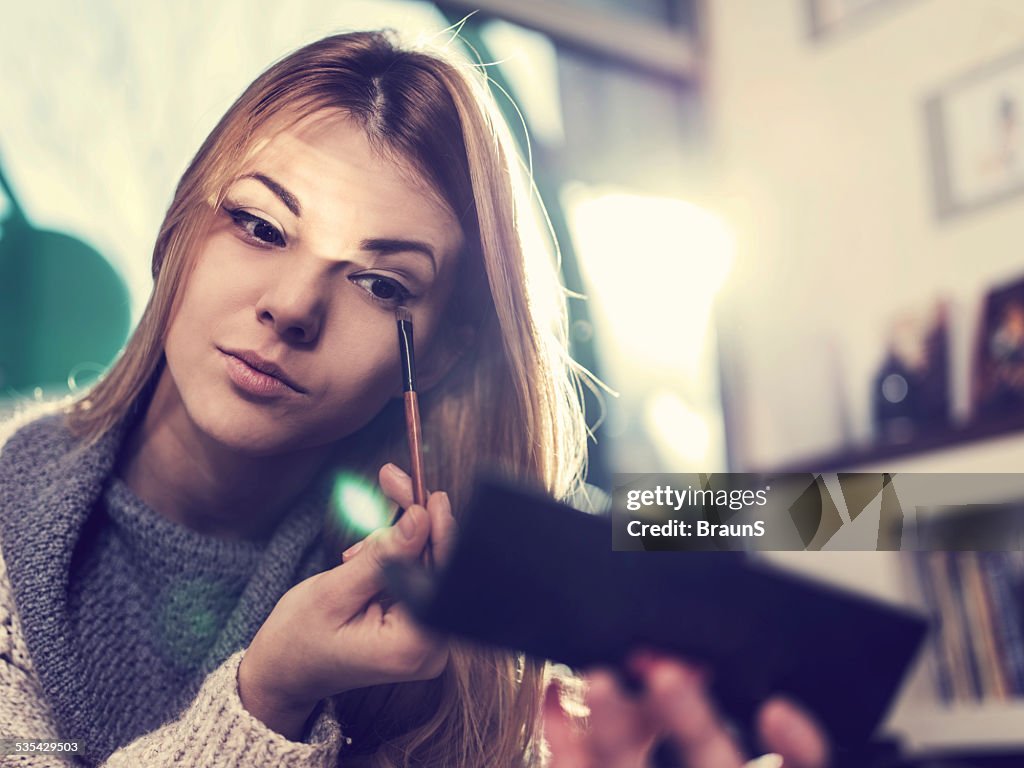 Woman fixing her make-up.