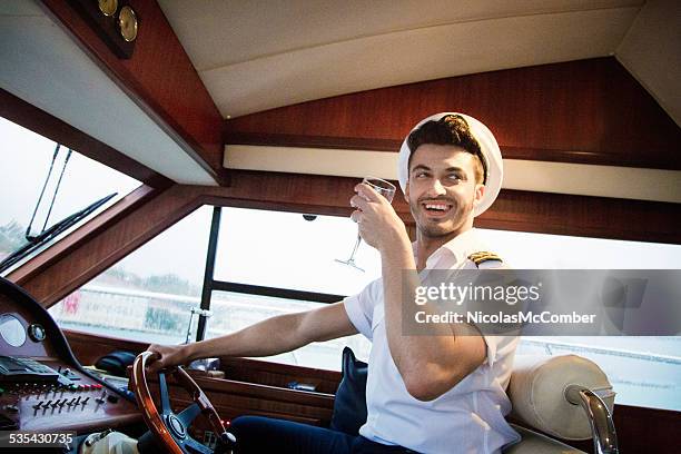 yacht captain enjoying party drink in hand - boat gps stockfoto's en -beelden