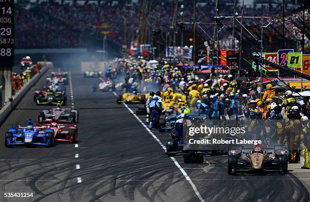 James Hinchcliffe of Canada driver of the Schmidt Peterson Motorsports Honda leads the field into the pits during the 100th running of the...