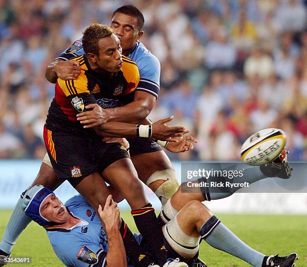 Sailosi Tagicakibau, center, of the New Zealand Chiefs dishes the ball of before being wrapped up by the New South Wales Waratahs' Daniel Vickerman,...