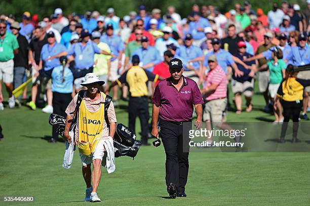 Rocco Mediate and his caddy walk to the 18th green as a crowd of fans follow during the final round of the 2016 Senior PGA Championship presented by...