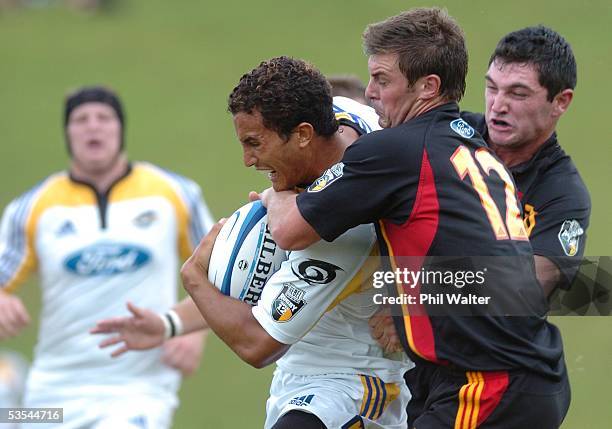 Hurricanes Tane Tuipulotu is held by Chiefs Grant McQuoid and Stephen Donald in their pre season Super 12 warm up match played at the Growers Stadium...