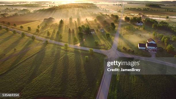 magische sonnenaufgang durch boden nebel mit sonnenstrahlen und lange schatten - mittlerer westen stock-fotos und bilder