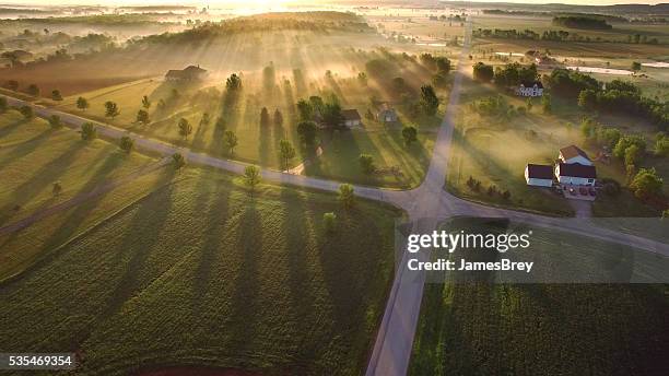 magische sonnenaufgang durch boden nebel mit sonnenstrahlen und lange schatten - beautiful house stock-fotos und bilder