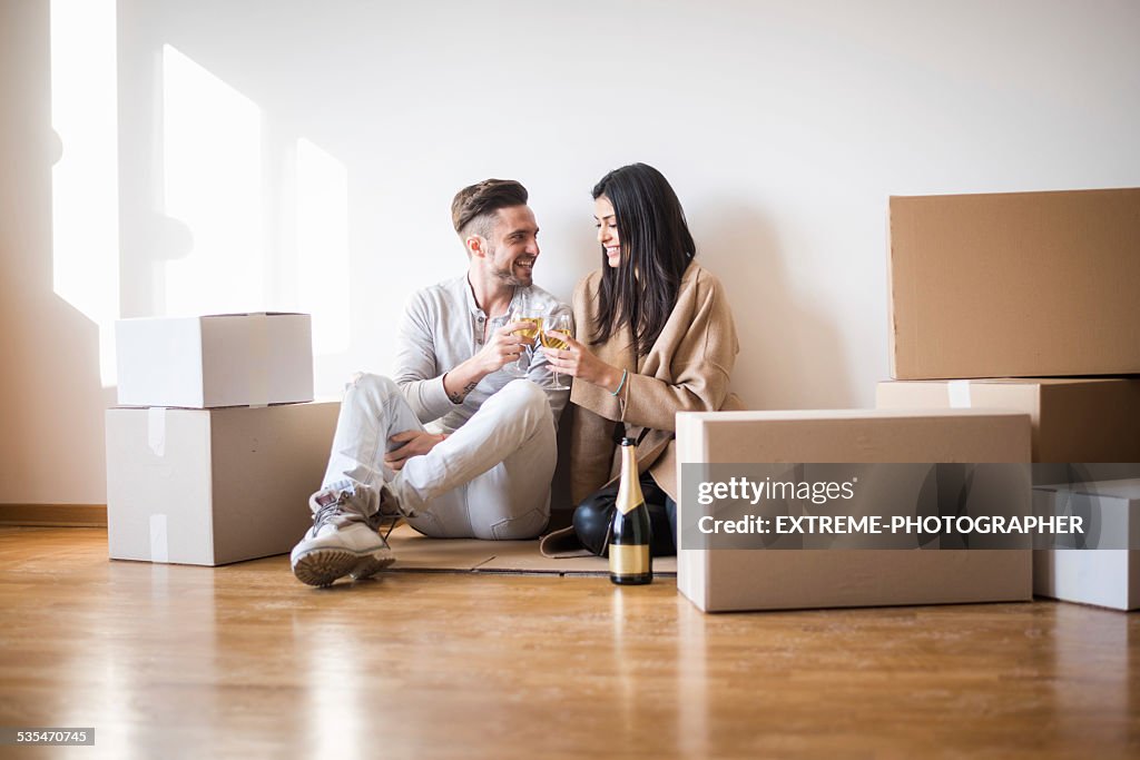 Couple having toast on the floor of new apartment