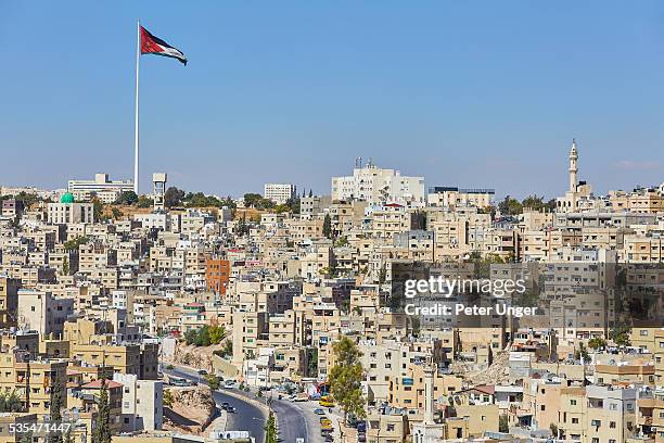 jordan flag flying on large flag pole in amman - アンマン市 ストックフォトと画像