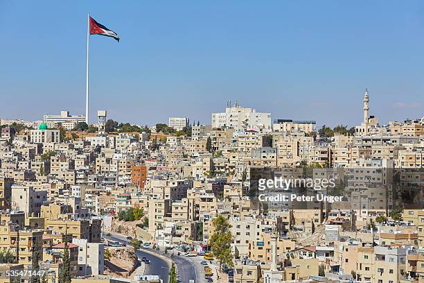 jordan flag flying on large flag pole in amman - amman stock pictures, royalty-free photos & images