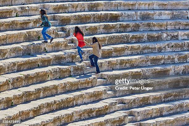 locals climbing the roman amphitheatre - amman people stock pictures, royalty-free photos & images