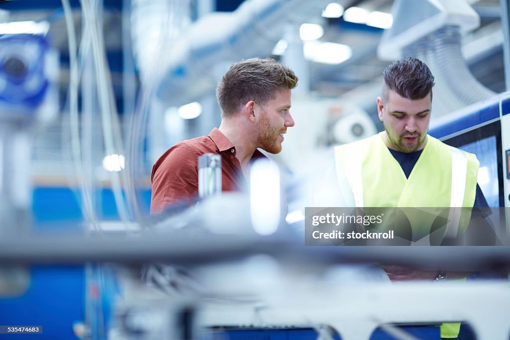 Young manager with foreman on factory shopfloor