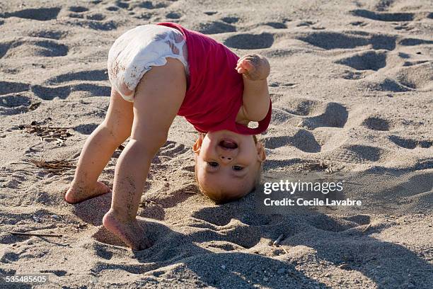 upside down baby girl at the beach - diaper girl stock pictures, royalty-free photos & images