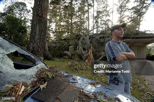 Tommy Townsend stands in front of his damaged car and home the day after Hurricane Katrina made her way inland August 30, 2005 in Meridian,...