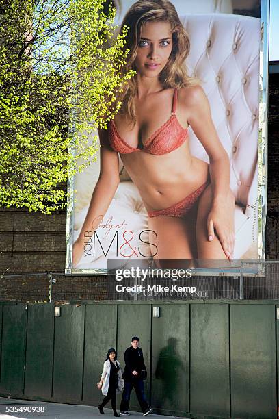 People walk past a huge advertising billboard poster for M&S with Ana Beatriz Barros. Lingerie or underwear for Marks and Spencer is big business and...