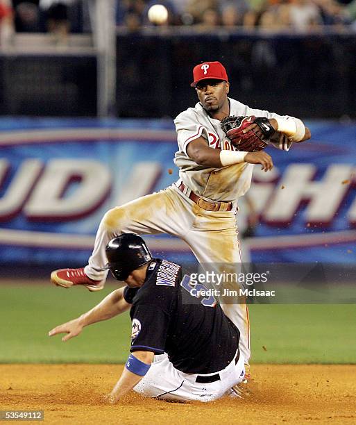 Shortstop Jimmy Rollins of the Philadelphia Phillies throws to first to complete a double play after forcing out David Wright of the New York Mets on...
