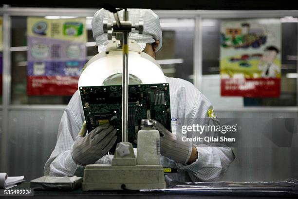 Employees work on the assembly line at Hon Hai Group's Foxconn plant in Shenzhen, China, on Wednesday, May 26, 2010. Hon Hai is the parts supplier...