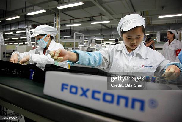 Employees work on the assembly line at Hon Hai Group's Foxconn plant in Shenzhen, China, on Wednesday, May 26, 2010. Hon Hai is the parts supplier...