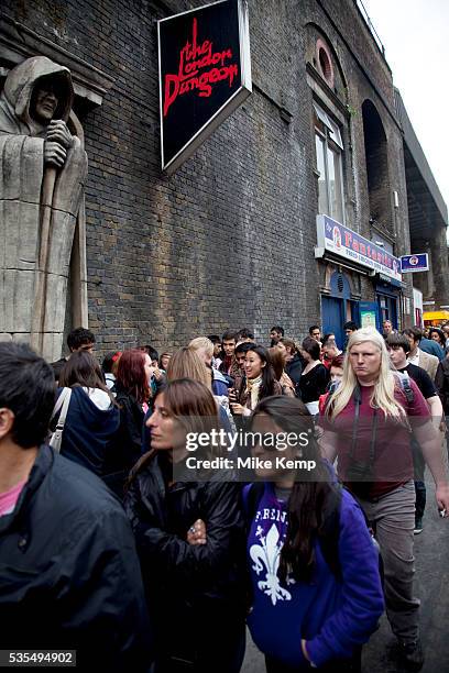 Tourists queue up outside the London Dungeons at London Bridge. The London Dungeon is a popular London tourist attraction,[1] which recreates various...