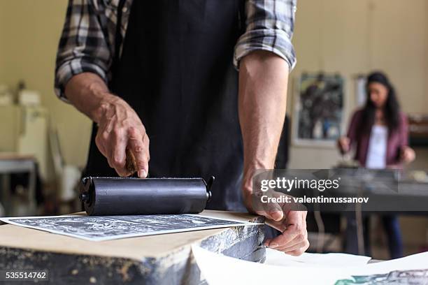 close up of male lithograph worker using printing roller - lithograph stockfoto's en -beelden