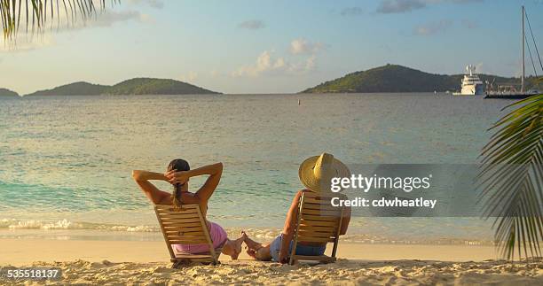 couple in beach chairs, playing footsie and watching sunset - playing footsie stock pictures, royalty-free photos & images