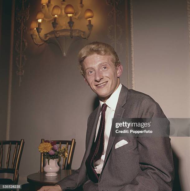 Manchester United and Scotland footballer, Denis Law posed wearing a grey suit and red striped tie in 1962.