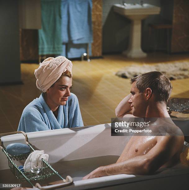 Greek actress Melina Mercouri pictured with actor George Peppard lying in a bath tub on the set of the film 'The Victors' in 1962.