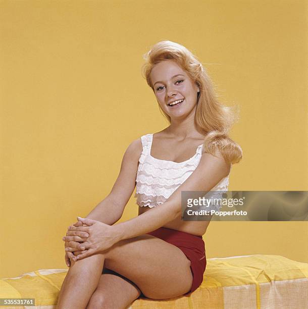 English actress Francesca Annis pictured wearing a white peasant style cropped top and red shorts in 1962.