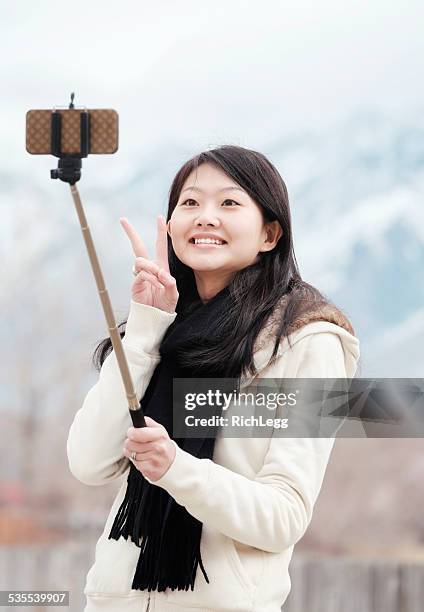 japanische frau mit selfie-stick - selfiestick stock-fotos und bilder